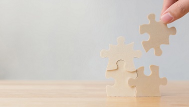 Wer macht was? (Quelle: Chaiyawat - Fotolia) Das Bild zeigt eine Hand, die Puzzleteile zusammenfügen.