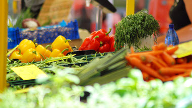 Das Bild zeigt gelbe und rote Paprika auf einem Marktspand. (Quelle: TiM Caspary / pixelio.de)