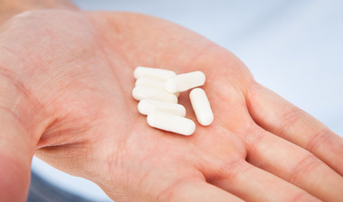 Bilanzierte Diäten (Quelle: Andrey Popov / Fotolia) Das Bild zeigt eine Handfläche mit weißen Pillen. (Quelle: Andrey Popov / Fotolia)